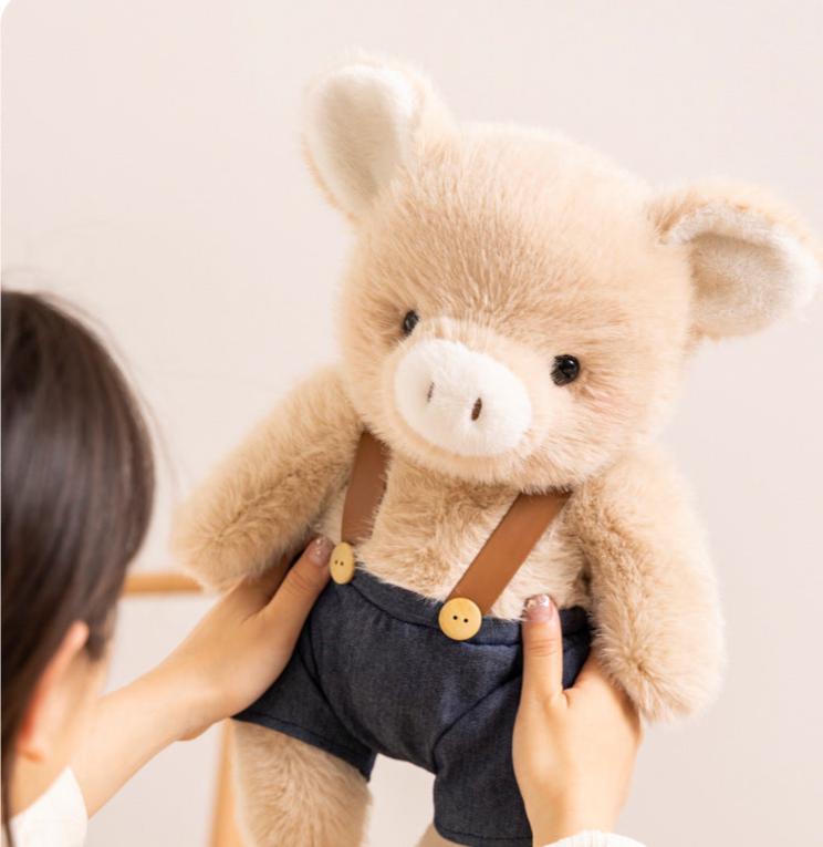 Duo di peluche a forma di maialino vestito